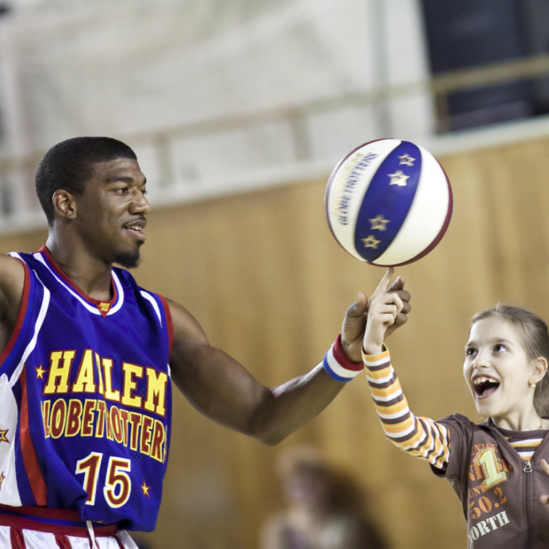 Harlem Globetrotter Letting a Child Spin the Ball