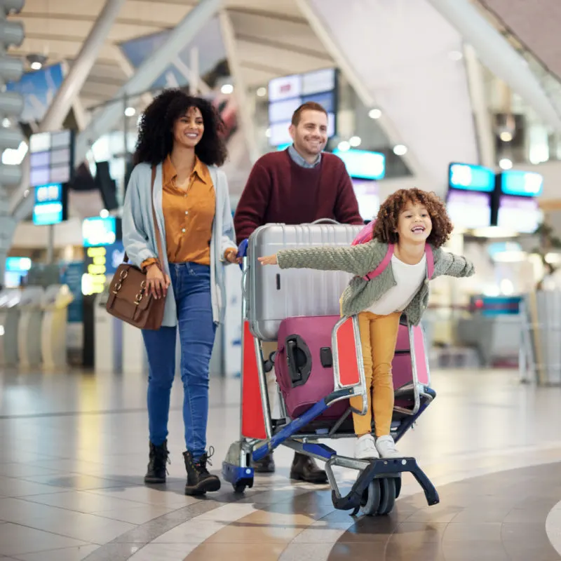 family at airport with little girl on cart