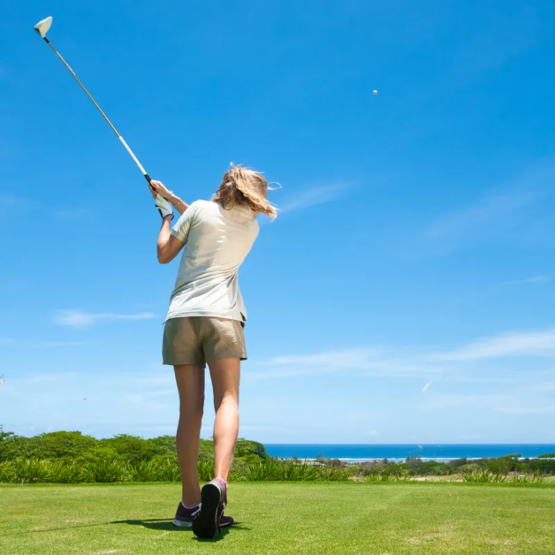 female golfer by the beach