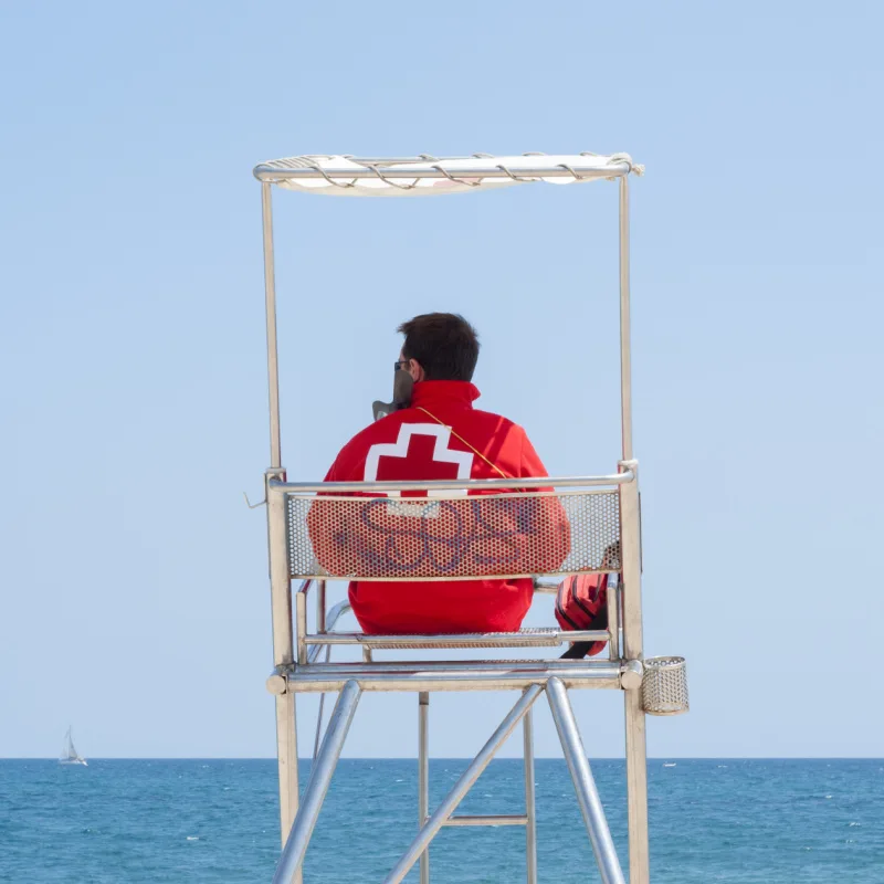 lifeguard sitting surveying beach