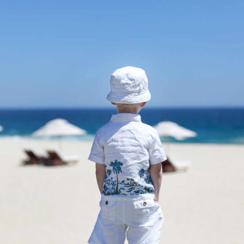 little boy at beach facing ocean
