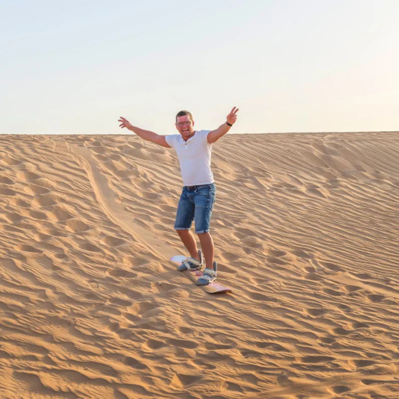 man sand boarding 