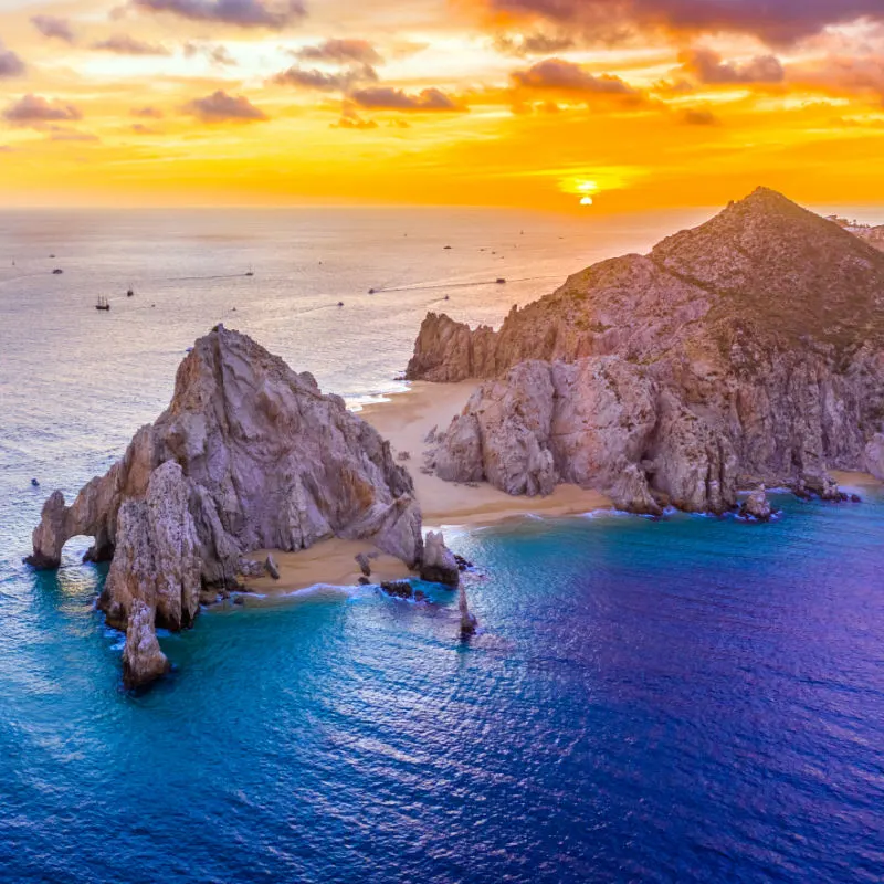 rock formation in ocean los cabos at sunset