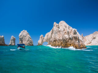 Cliffs in the sea with a boat at Los Cabos