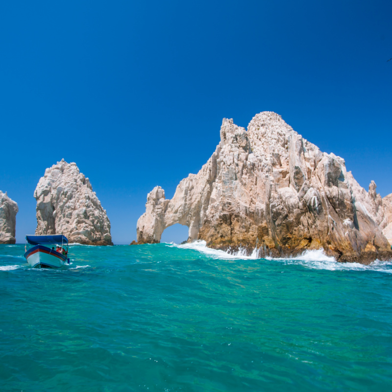 Cliffs in the sea with a boat in Los Cabos