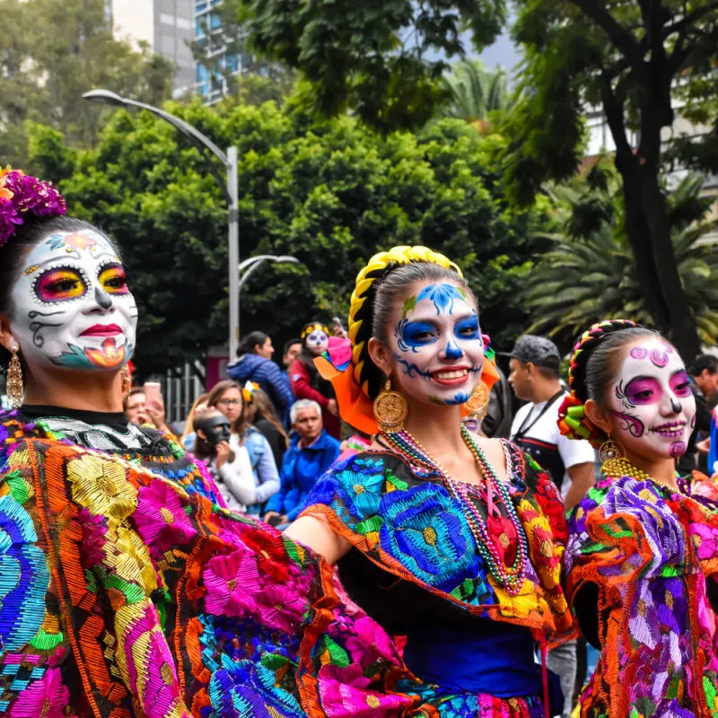 three women dressed for dia de los muertos