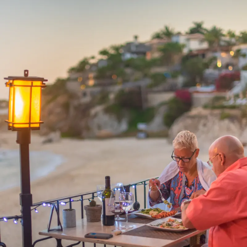 couple with wine at dinner in los cabos