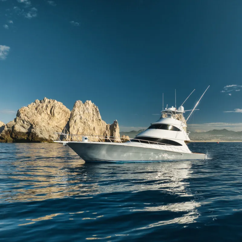 An elegant sportfishing yacht in the ocean in Cabo, Mexico sailing leisurely through a tranquil bay
