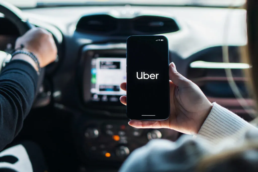 Girl Looking at the Uber App While Riding in a Car