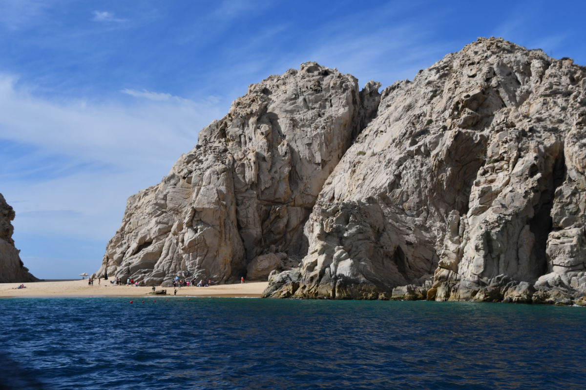 Cliffs in Los Cabos with tourists on a beach on a sunny day