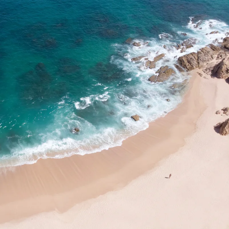 Aerial photo of one man walking on isolated and lonely Playa El Chileno beach