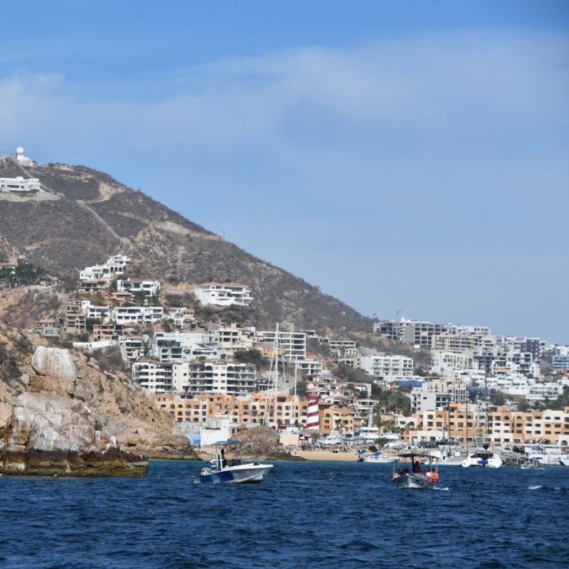 Coast of Cabo San Lucas on a sunny day with mountain in the background