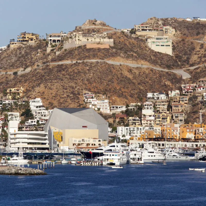Downtown-area-of-Cabo-San-Lucas-seen-from-the-sea.-Mountains-in-the-background-and-buildings-on-the-front-on-a-sunny-day-1