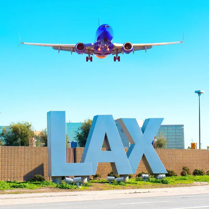 Plane landing above the LAX sign in LA