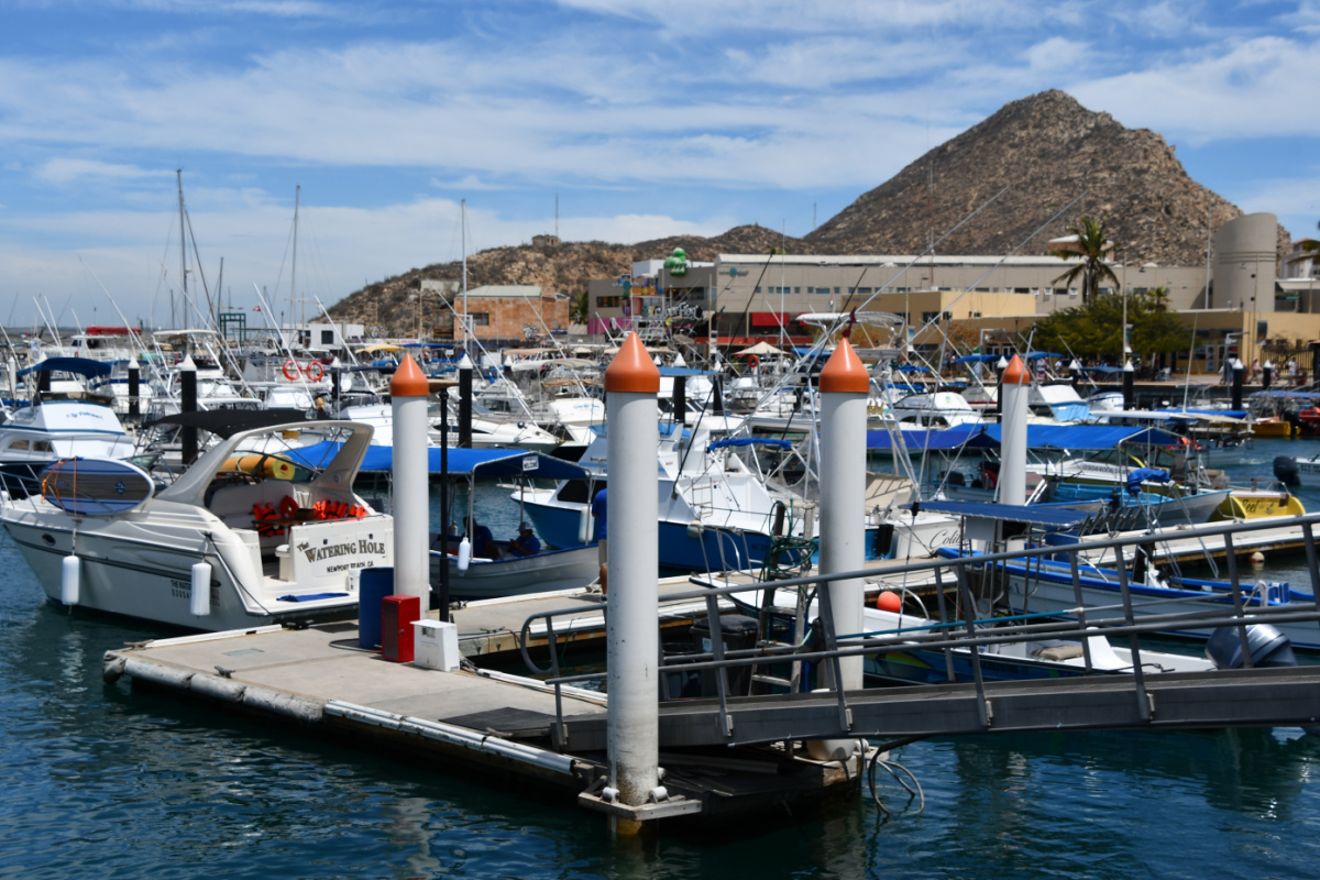 Boats in the Cabo San Lucas marina with mountain in the background on a sunny day