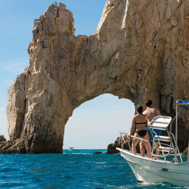 Los Cabos arch with boat of tourists approaching