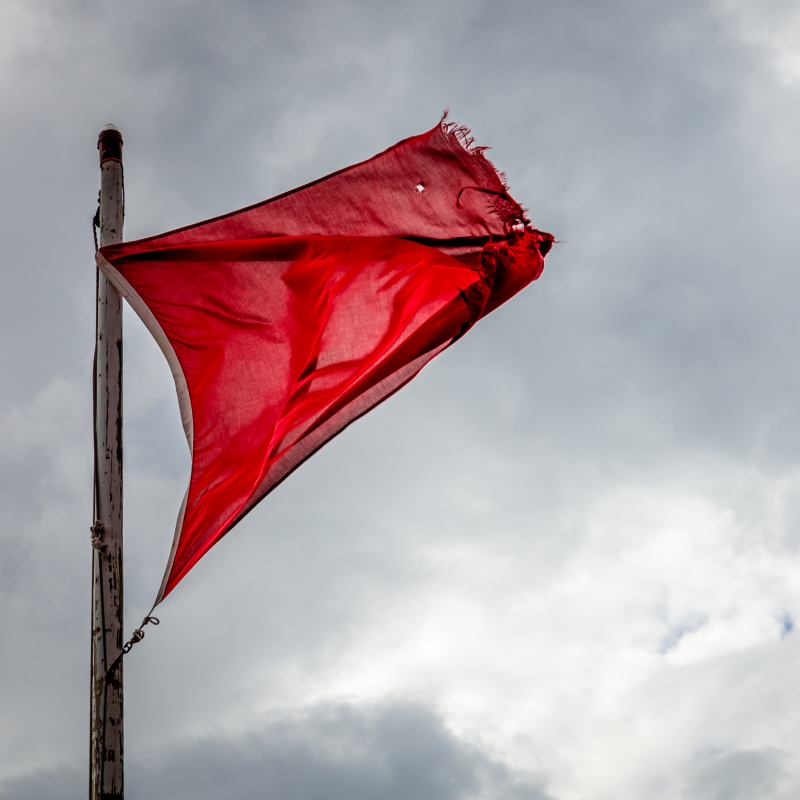 Red flag with stormy sky in the background