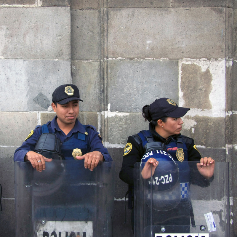 Three Mexican Police Officers in Riot Gear outside building in Zocalo Square, Mexico City