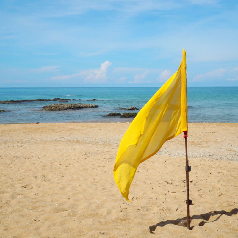 Yellow flag on a beach on a sunny day