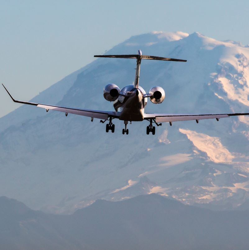 A plane with a mountain in the background over Seattle