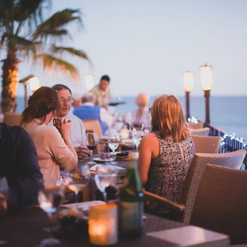 tourists eating dinner with wine in cabo