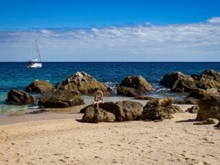 Photo of a woman on the rocks at Playa Chileno.