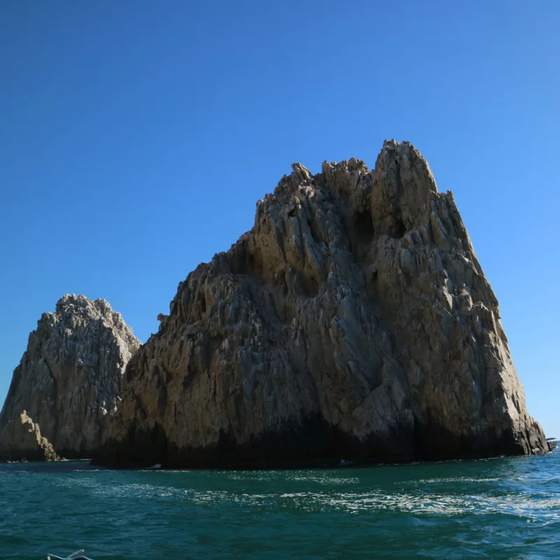 Rock formation in Los Cabos surrounded by sea on a sunny day