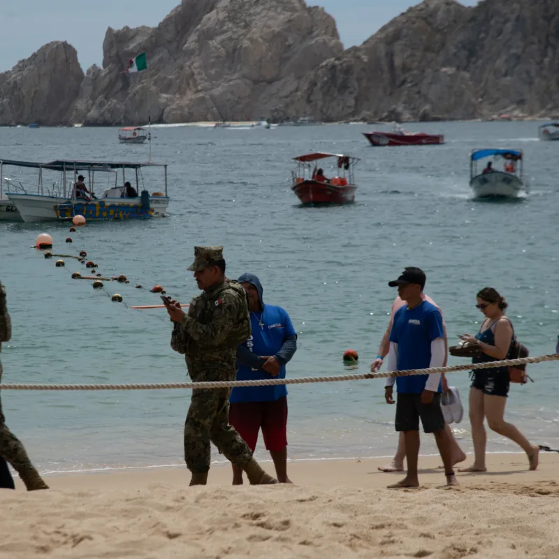 Tourists and Security on the Beach in Front of the Arch in Cabo San Lucas, Mexico