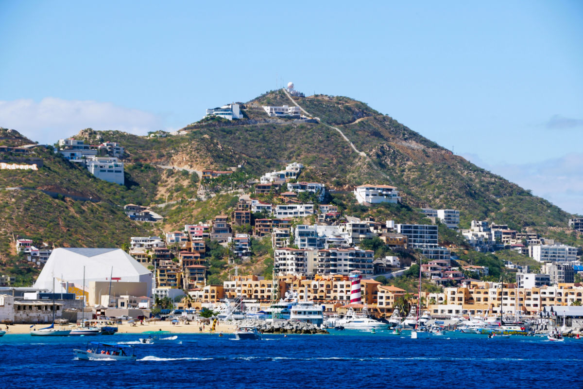 The view of a Los Cabos hill with luxury waterfront homes and resort hotels by the bay