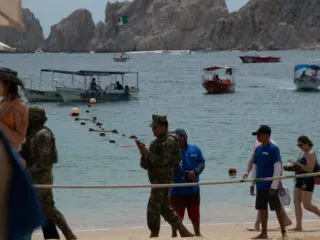 Tourists and Security on the Beach in Front of the Arch in Cabo San Lucas, Mexico