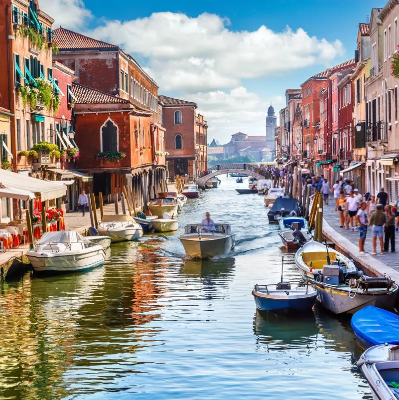 A canal in venice, Italy with tourists and boats
