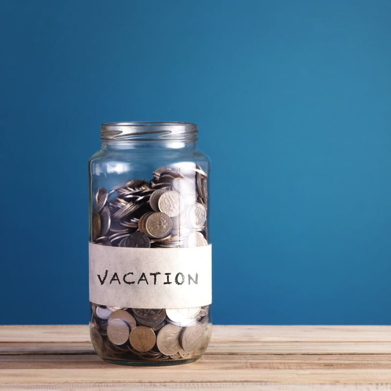 A jar full of coins with vacation written on it