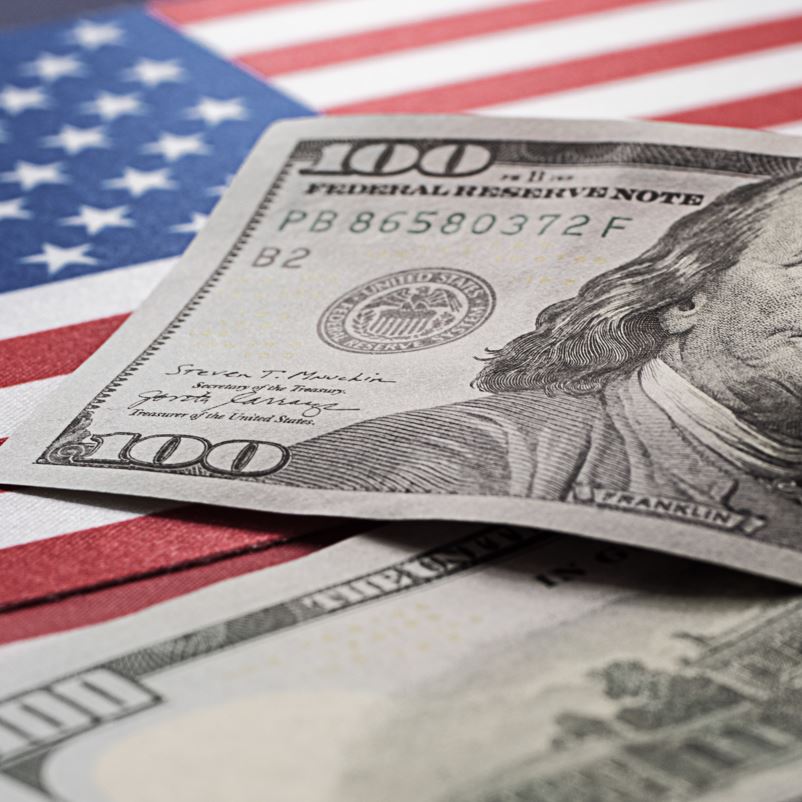 US 100 dollar bill sitting on an American flag