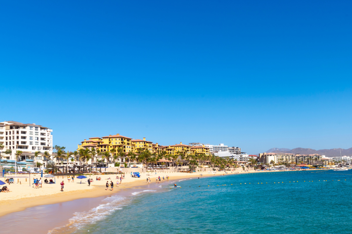 View of a beach in Los Cabos with people walking in the sand