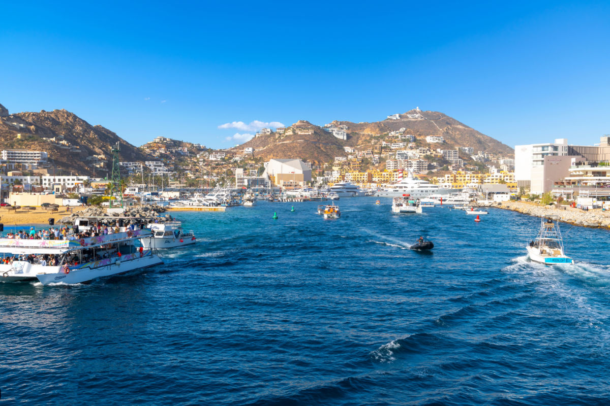 View from a boat in the bay of the marina, port town and hills of the Mexican resort town of Cabo San Lucas, Mexico.