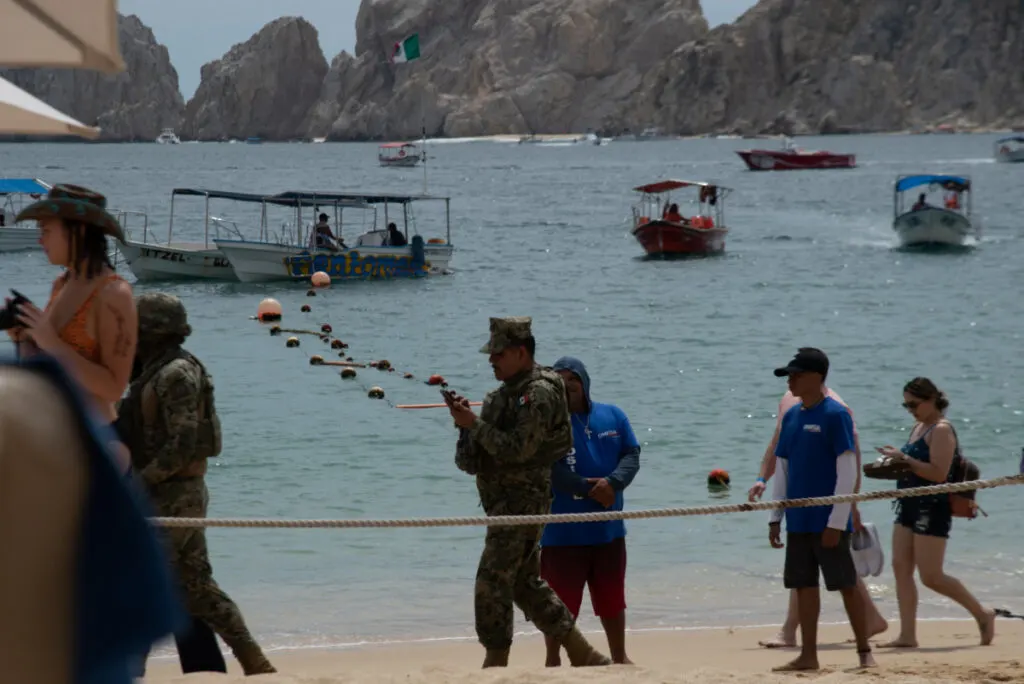 Tourists and Security on a Beach in Cabo San Lucas, Mexico