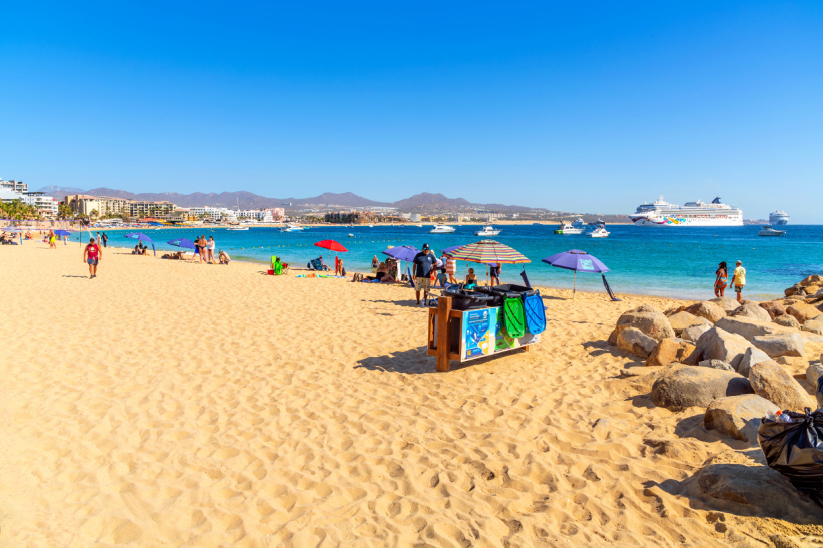 Los Cabos Beach with tourists and vendors on a sunny day