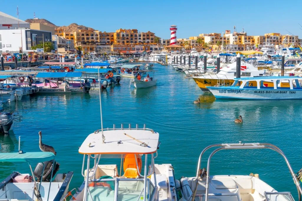 The colorful and busy cruise port with shops, cafes and boats in the marina along the Mexican Riviera at Cabo San Lucas, Mexico.