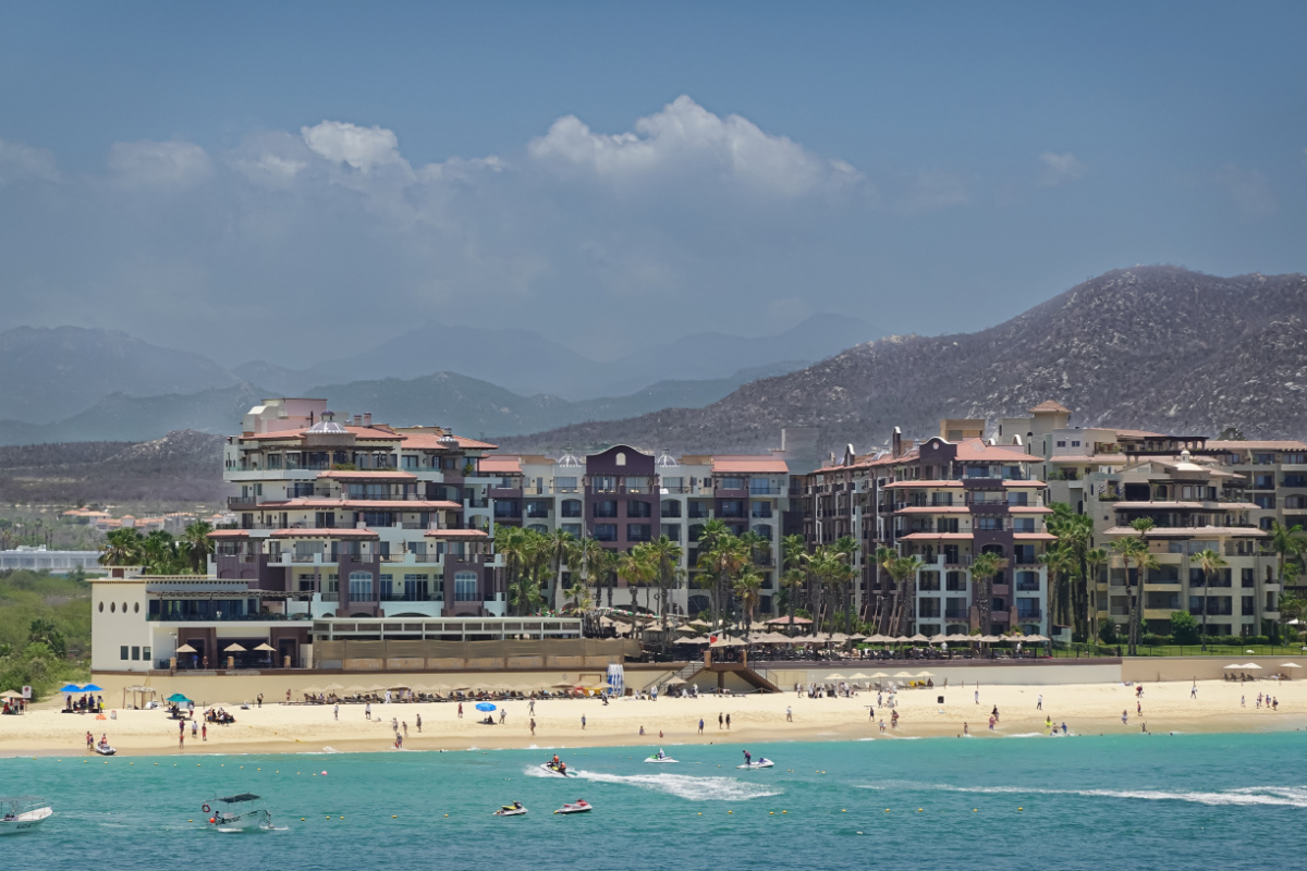 Tourists in the Water and on the Beach in Front of Villa del Arco Resort in Cabo San Lucas, Mexico