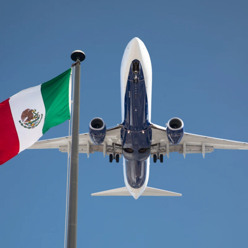 Plane Flying Above a Mexican Flag