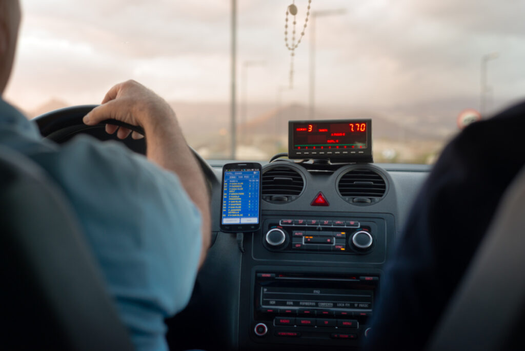 Driver in a Taxi with the Fare Displayed on a Meter