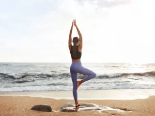 Woman Doing Yoga on the Beach