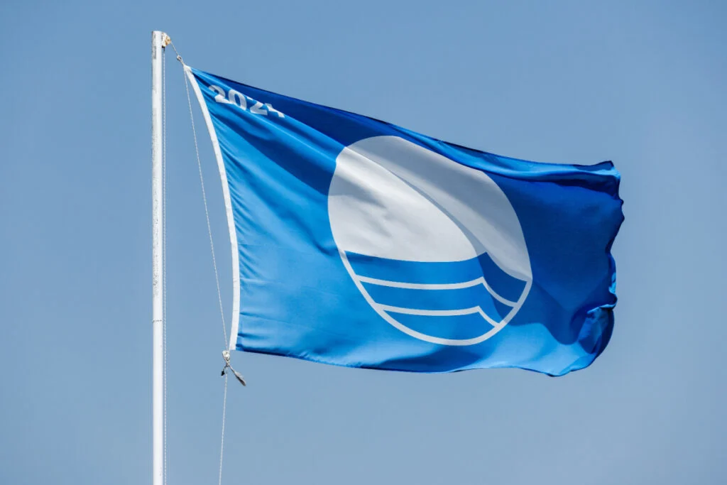 Blue Flag beach. Close-up photo of a flag waving under blue sky