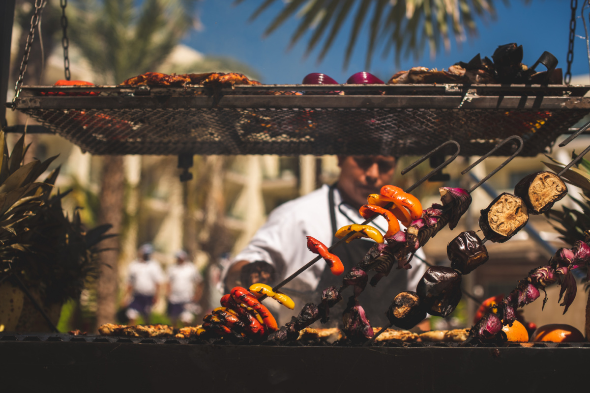 Man cooks food over a grill in Los Cabos