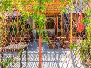 Todos Santos, Baja California Sur, Mexico. A restaurant courtyard seen through a metal fence.
