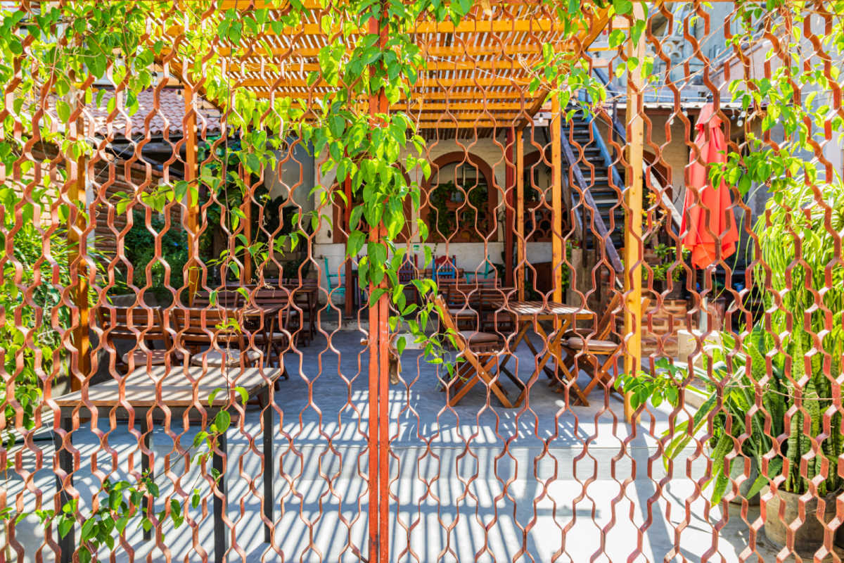 Todos Santos, Baja California Sur, Mexico. A restaurant courtyard seen through a metal fence.