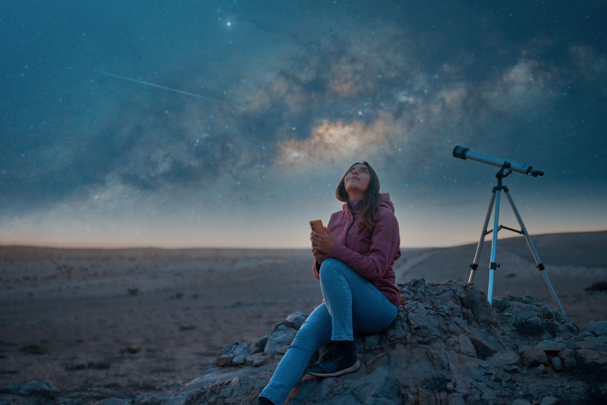 Woman stargazing in the desert