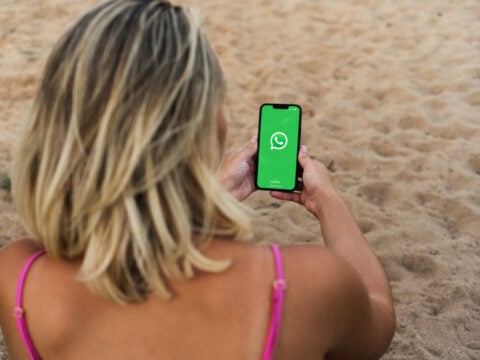 Woman on a beach with Whatsapp on her phone