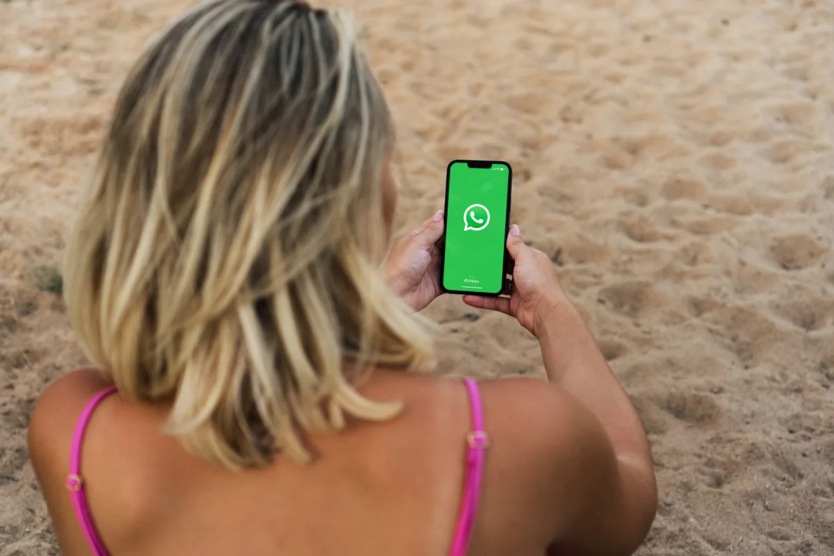 Woman on a beach with Whatsapp on her phone