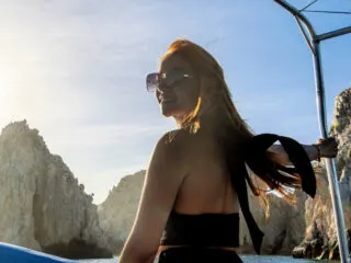 Woman on a boat in front of El Arco, the arch of cabo san lucas, los cabos